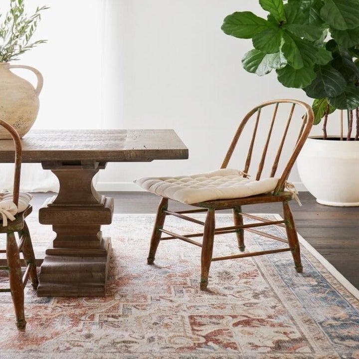 a red and blue area rug in a dining room