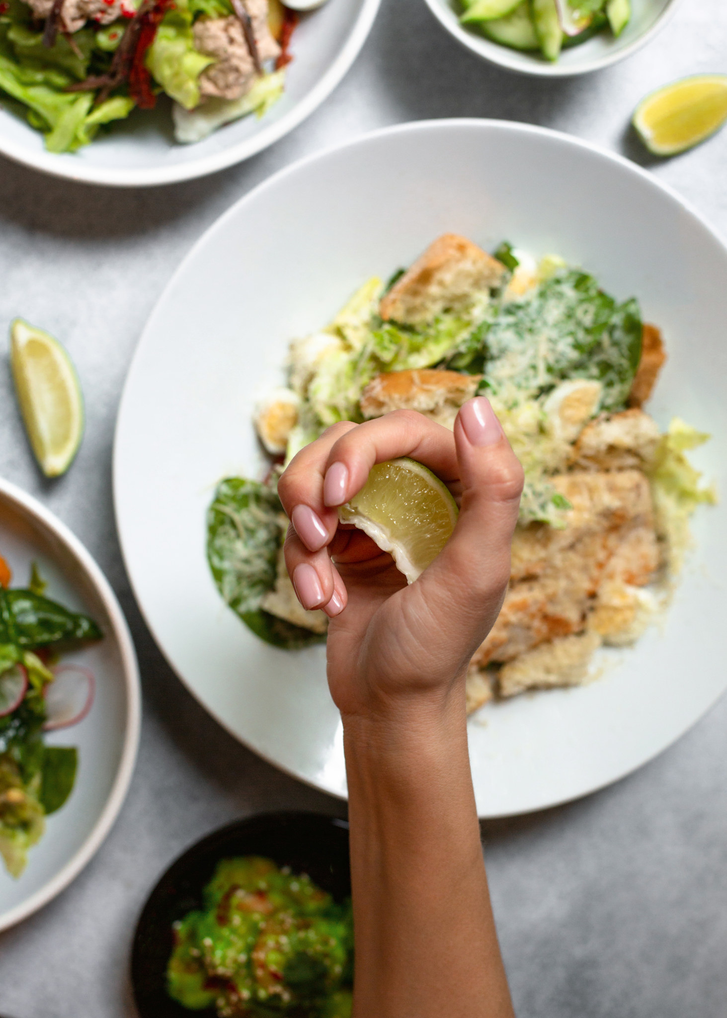 Squeezing lime over salad.