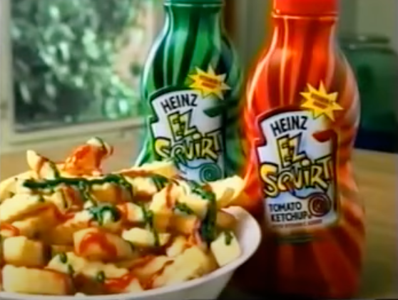 Heinz EZ Squirt in front of french fries drizzled with different colors of ketchup