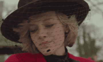Kirsten as Princess Diana shying away from the paparazzi cameras
