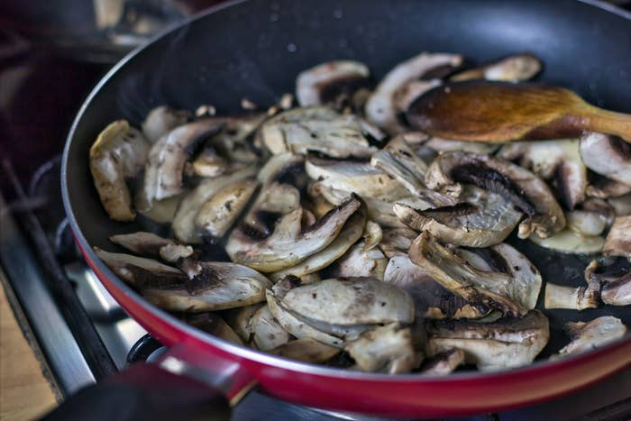 Browning sliced mushrooms in a skillet.