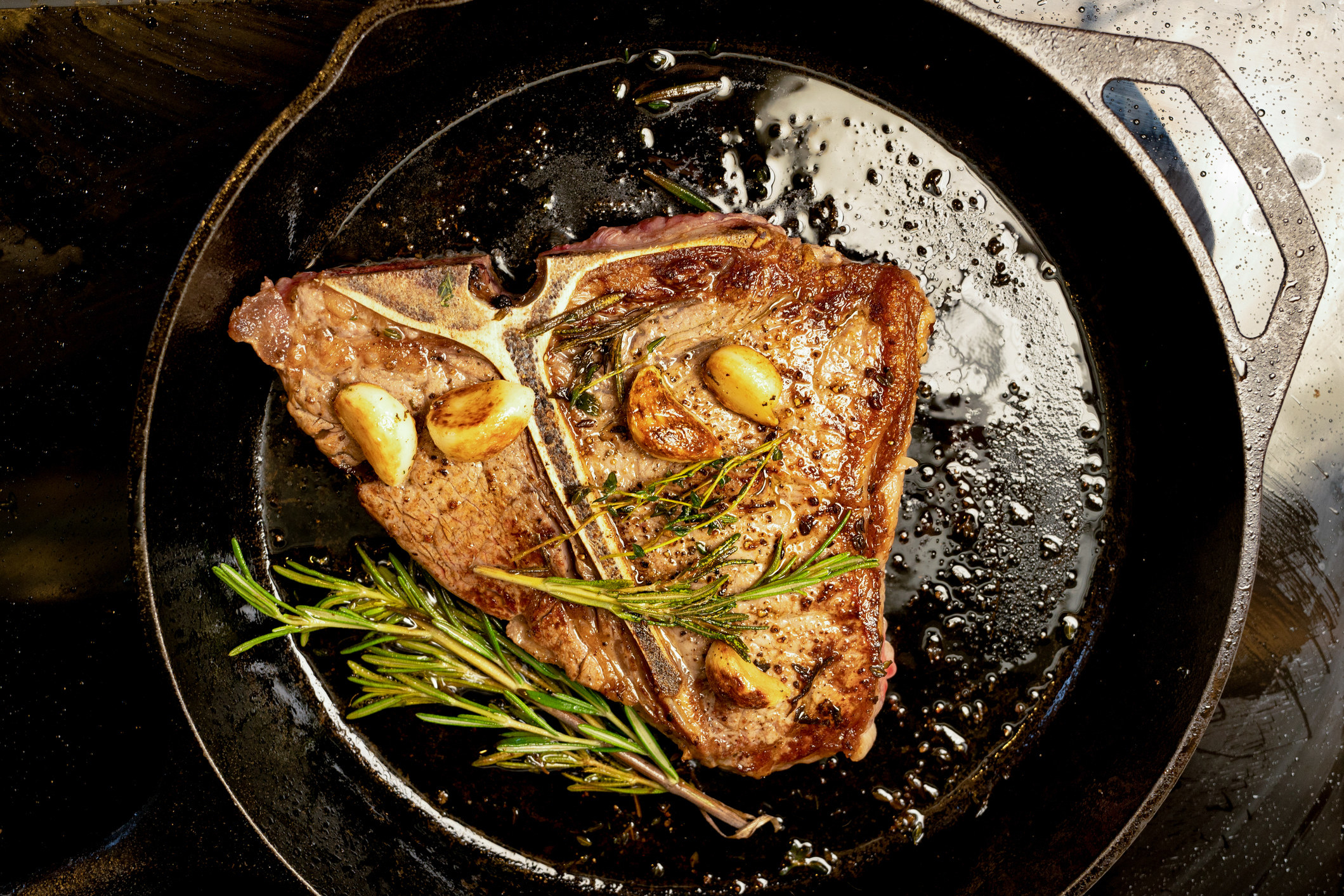 A T-Bone steak in a skillet.