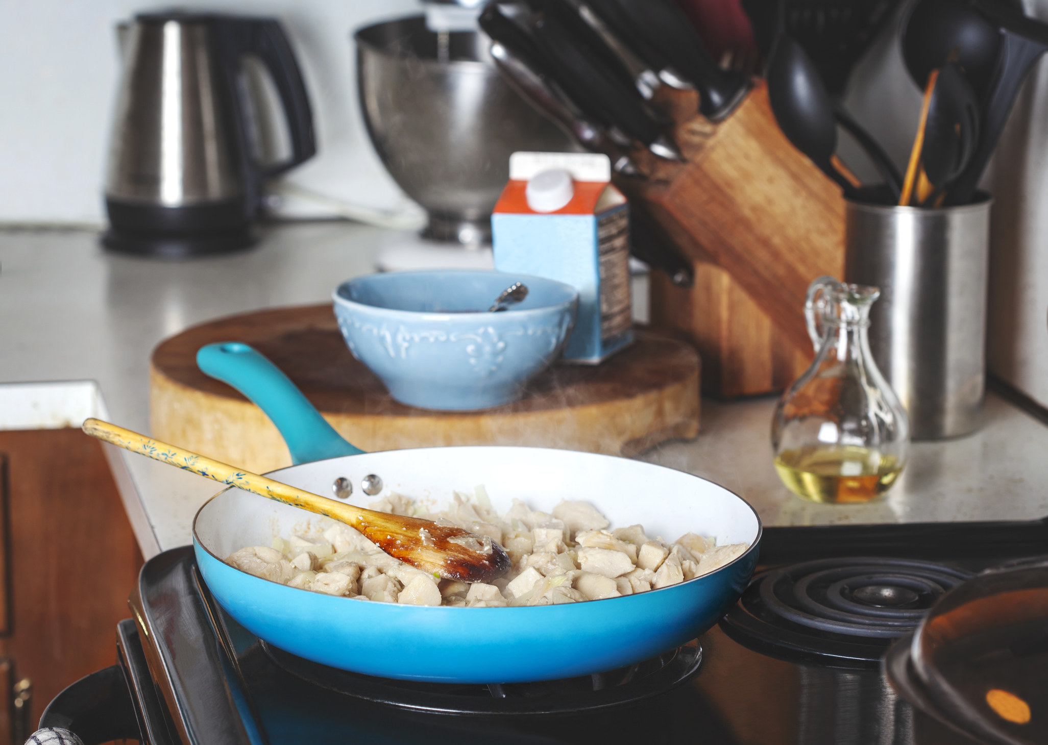 Cubes of chicken in a skillet.