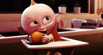 a gif of jack jack from the incredibles happily snuggling and chewing on an orange
