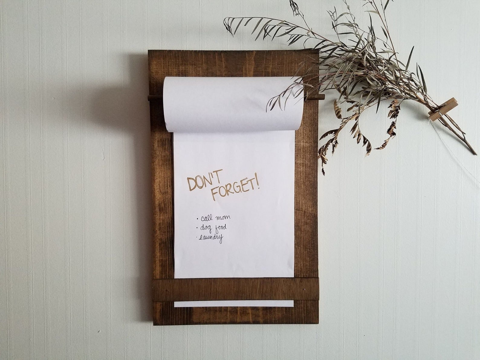 The hanging paper roll holder with don&#x27;t forget list written