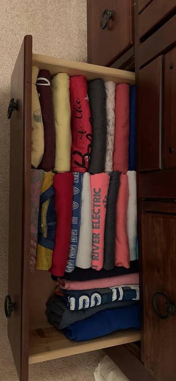 A reviewer's shirts folded neatly in a drawer so they can see the designs