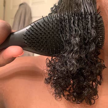 reviewer using the brush on their wet 4B type hair