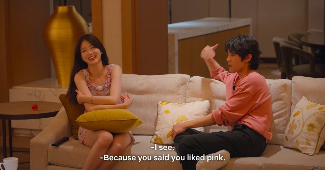 Si-hun and Ji-yeon laugh on a couch, Si-hun says he wore pink for her