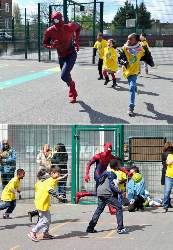 Andrew running on a playground in his Spider-Man suit alongside some children