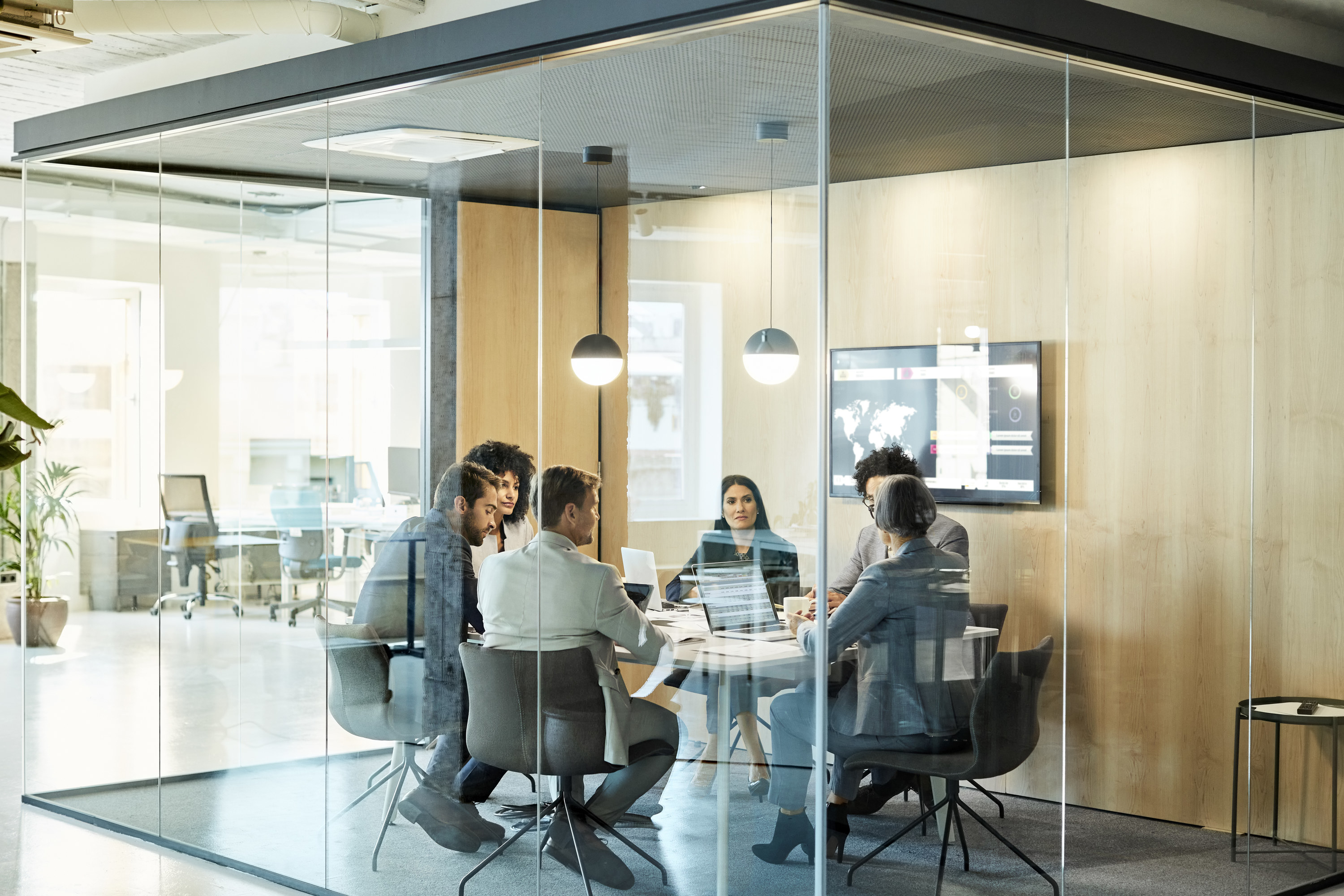 People sitting around a table in an enclosed conference room in an office