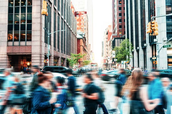 A blurred photo of people walking in a busy city