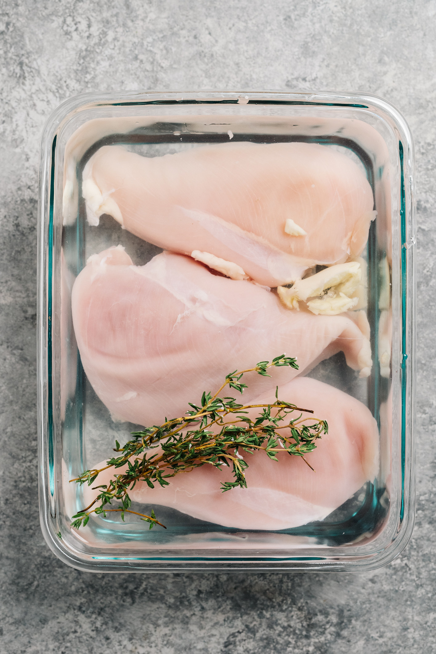 Chicken breasts brining with fresh thyme