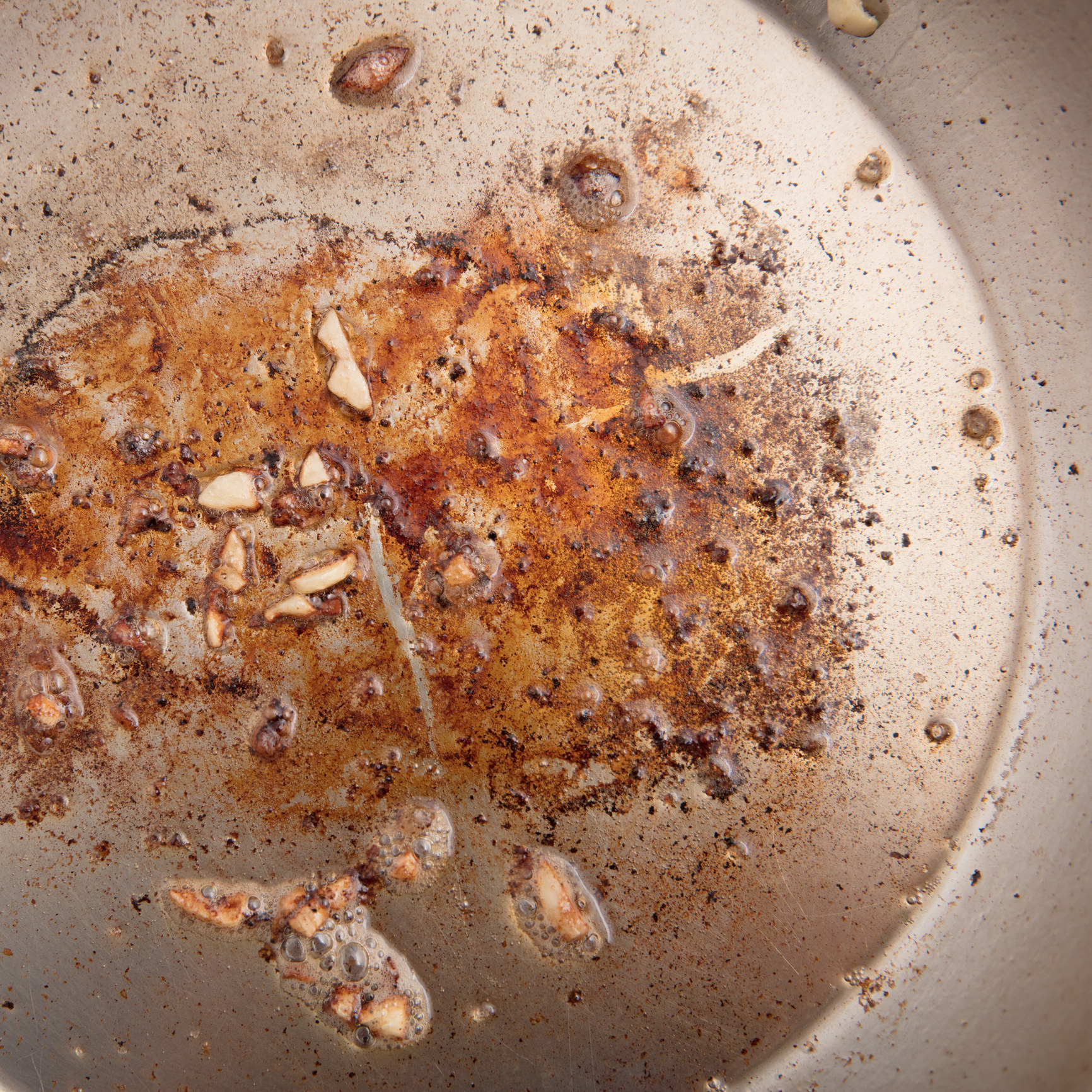 A pan with brown bits of food stuck to it.