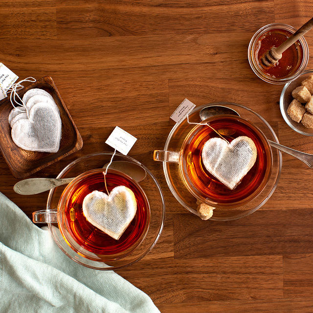 Two mugs with steeping heart-shaped tea bags