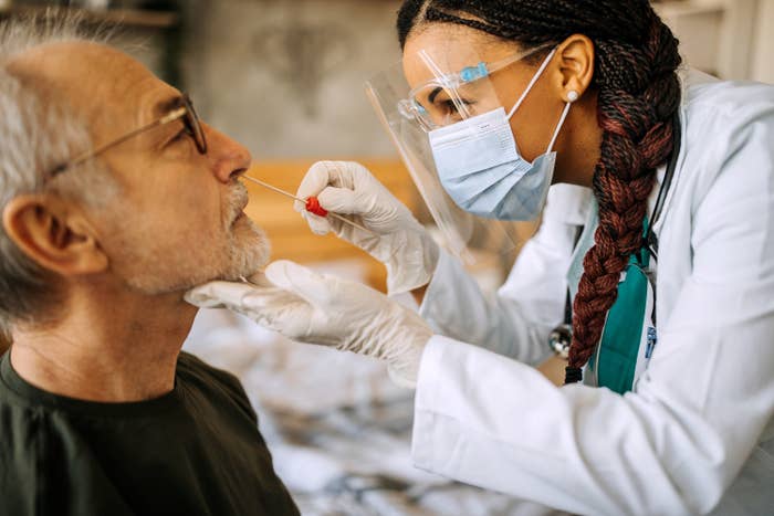 A nurse giving a male patient a Covid test
