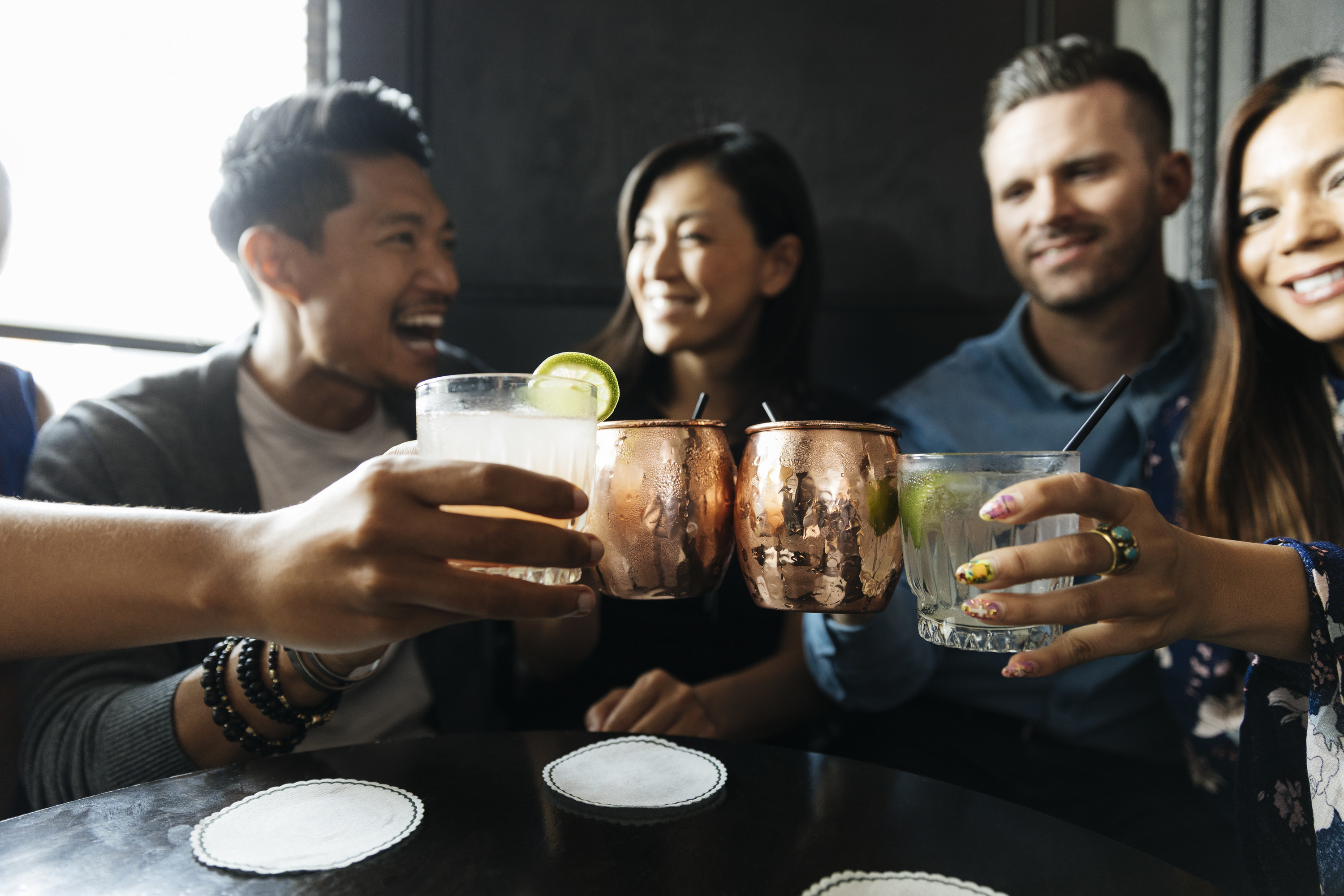 A group of friends saying cheers with their drinks at dinner