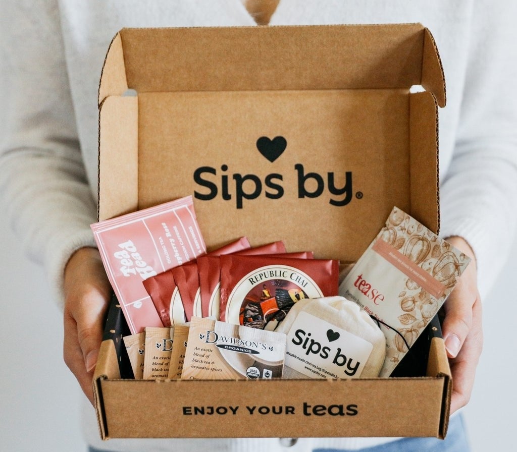 a model holding an open box filled with different kinds of tea