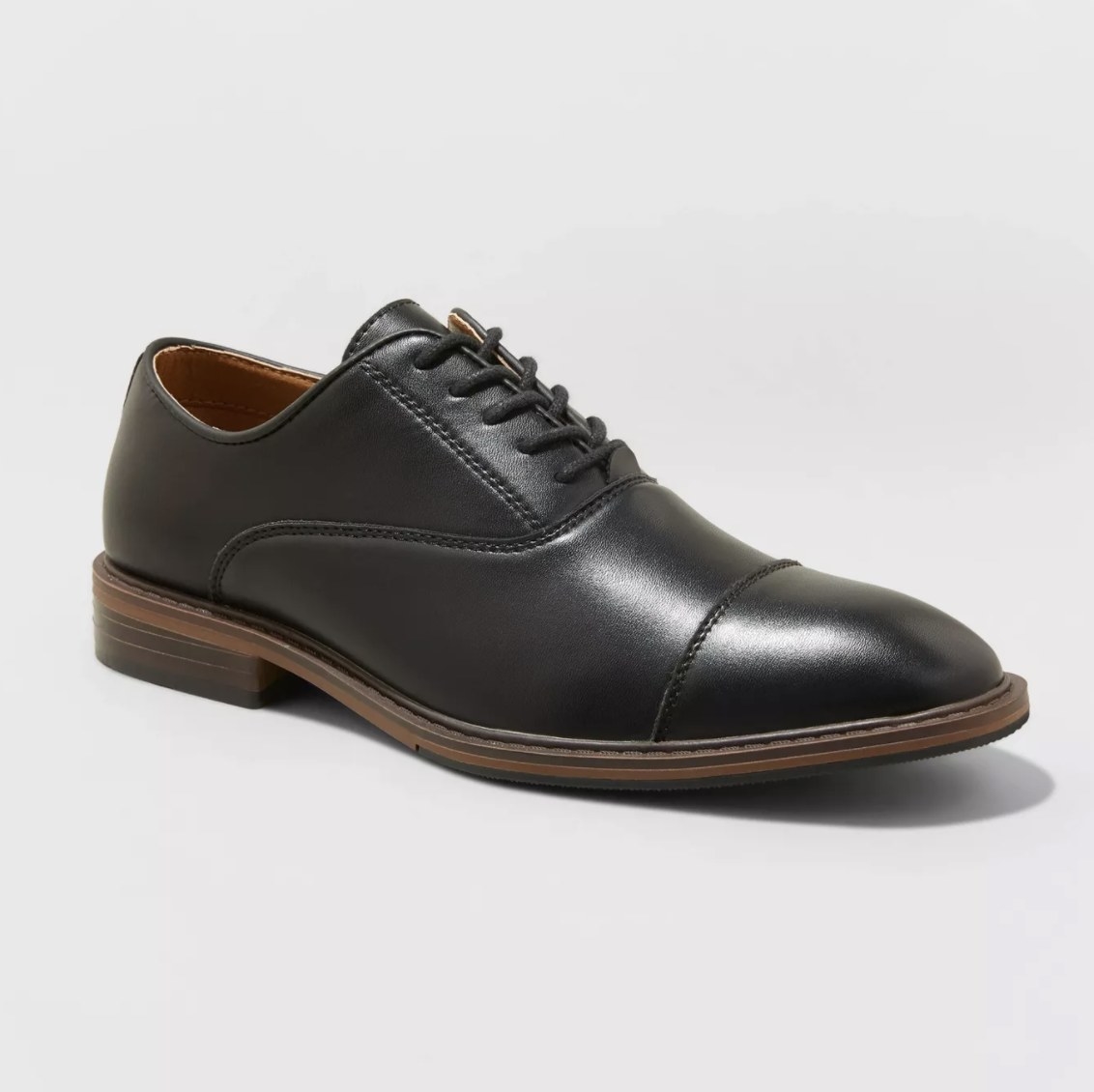 The black oxford shoes have a shiny exterior and a wooden sole