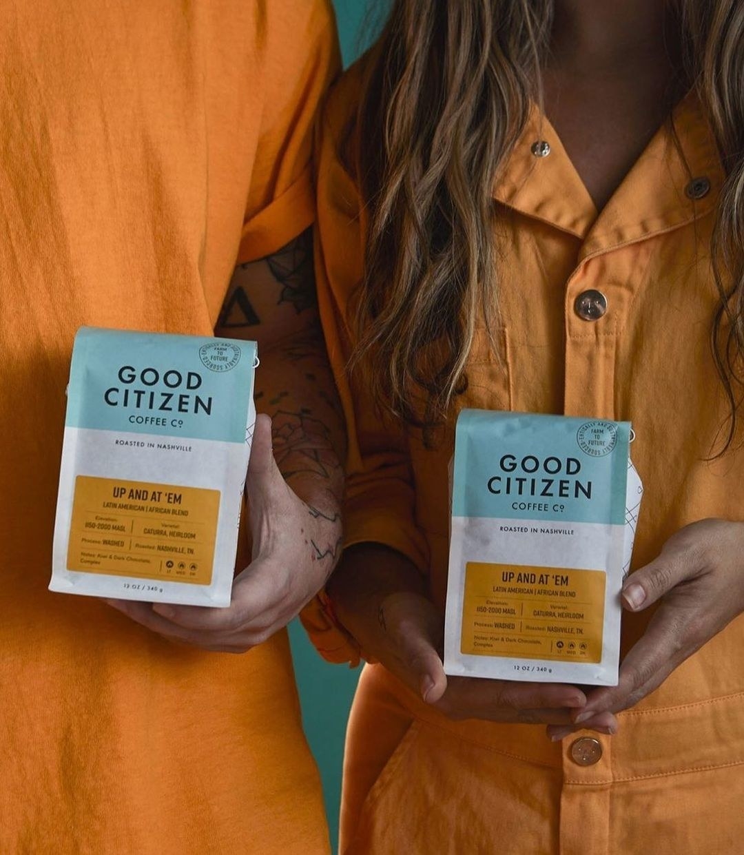 two people holding up good citizen coffee bags