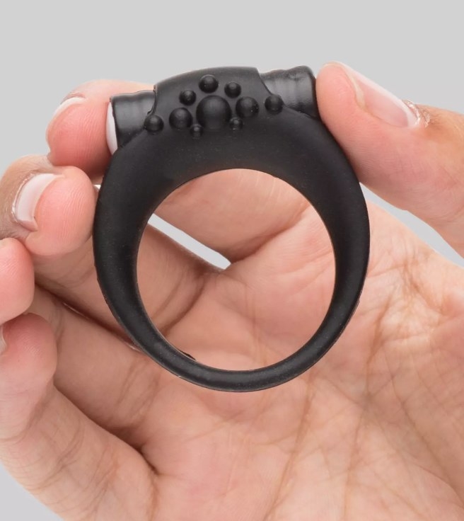 A model holding a black vibrating cock ring