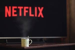 Netflix on TV with a cup of coffee in front of it.