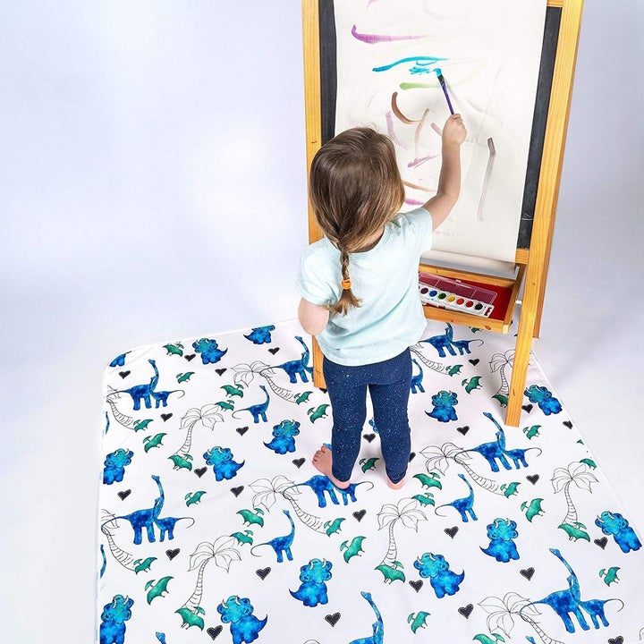 Child painting on easel on splat mat