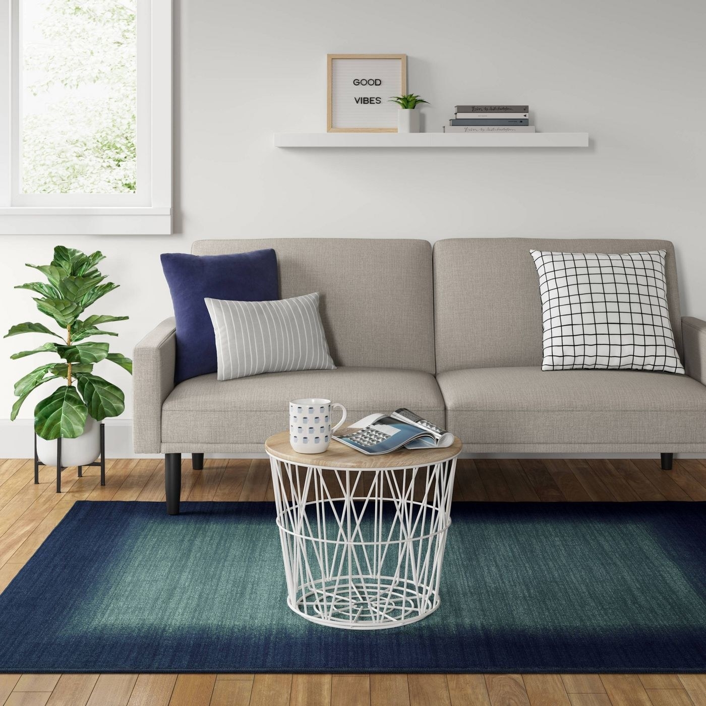 rectangular blue and green ombre area rug in front of a couch
