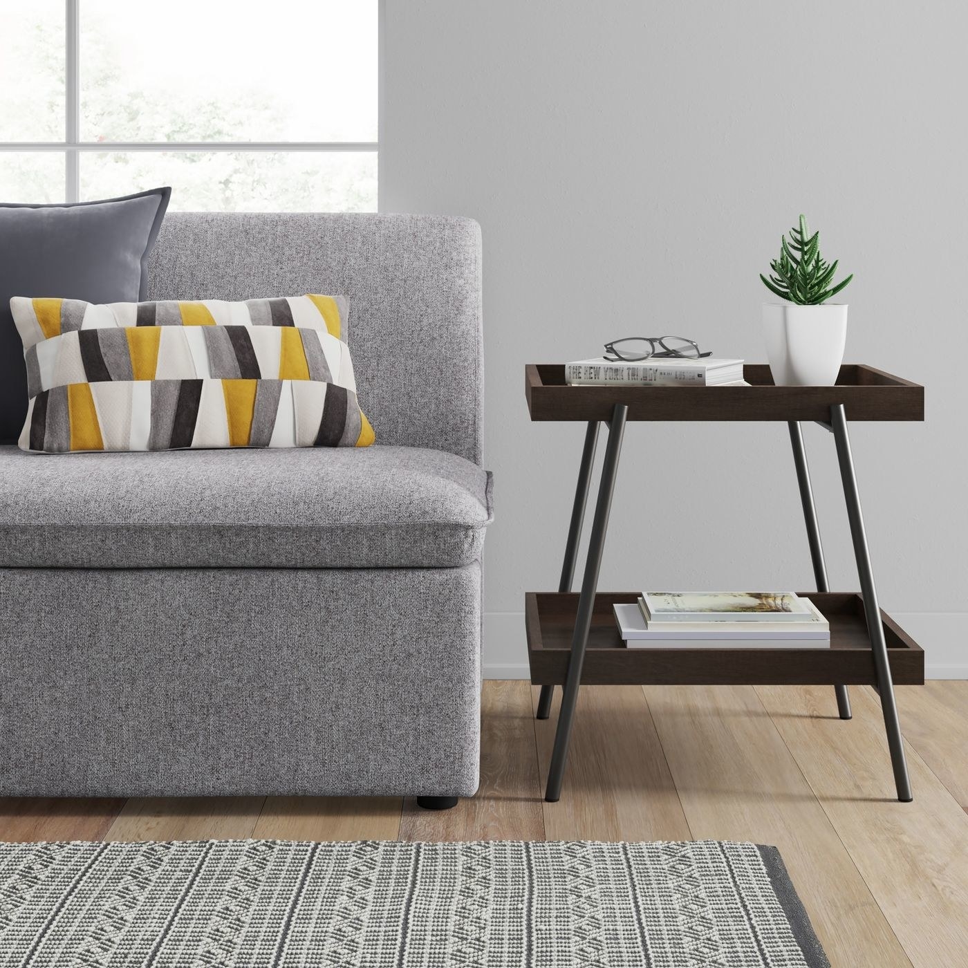 dark brown two-tier side table next to a gray couch