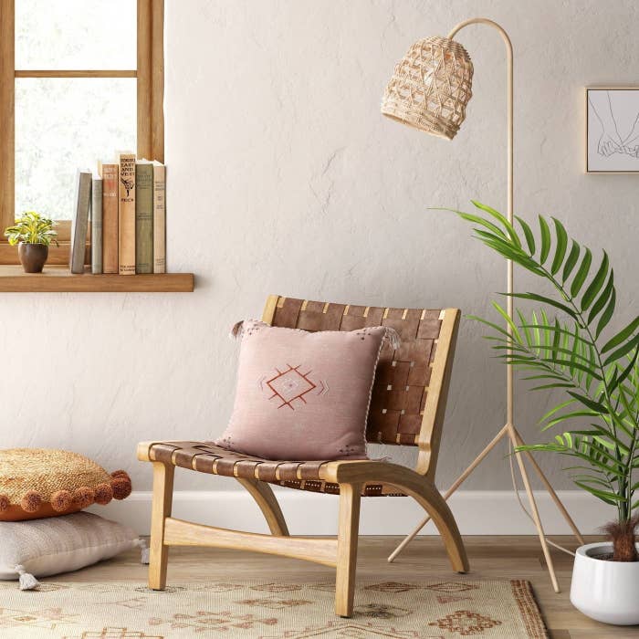 brown woven accent chair with pink throw pillow