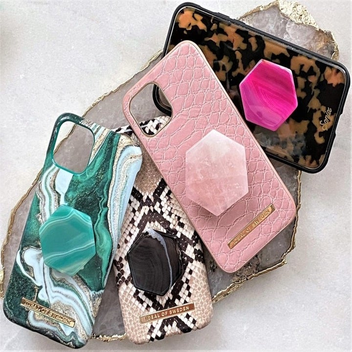 four phones with hexagon crystal phone grip caps on them