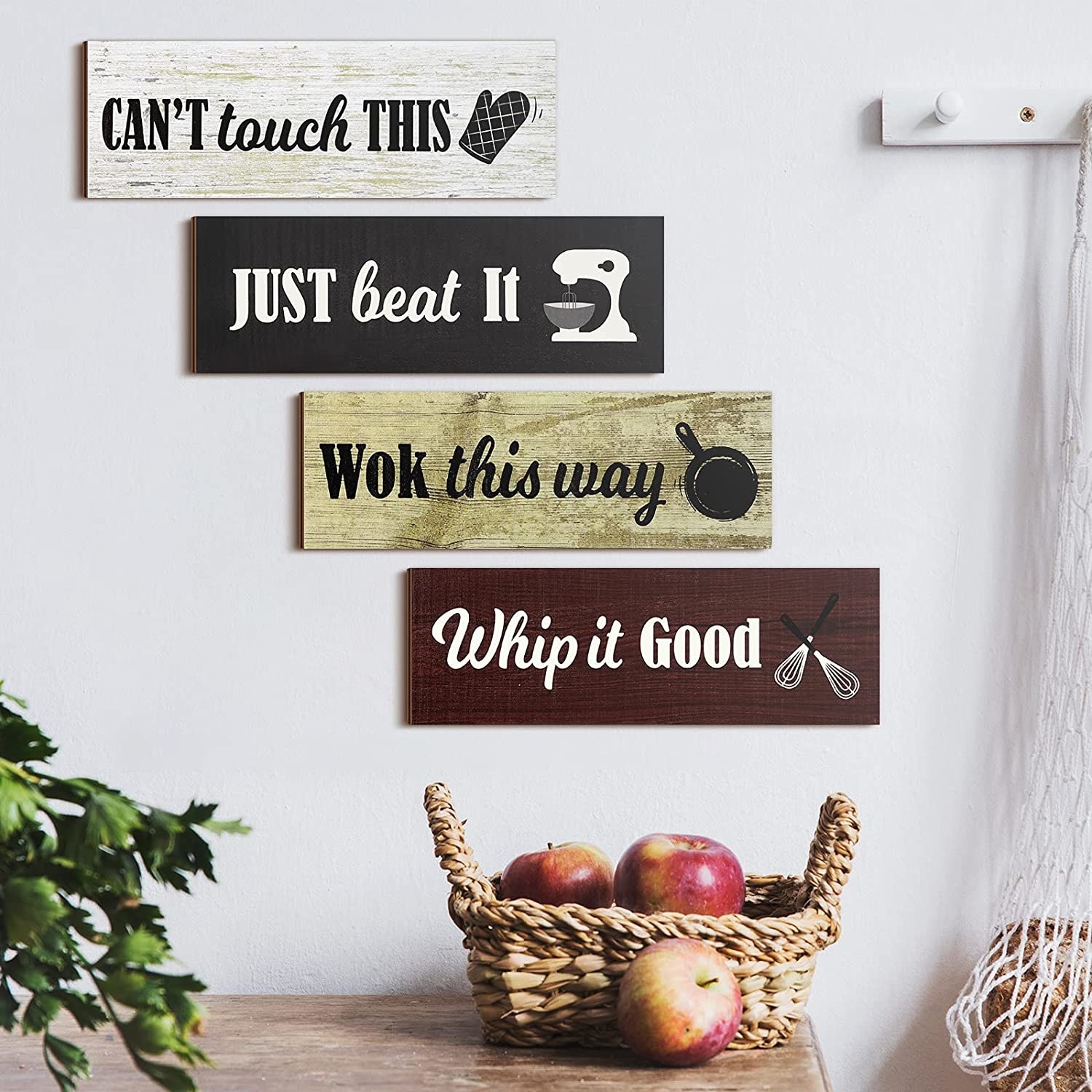 Wooden signs hanging on a wall in the kitchen reading &quot;can&#x27;t touch this&quot;, &quot;just beat it&quot;, &quot;wok this way&quot;, and &quot;whip it good&quot;