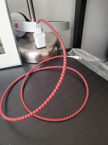 a reviewer's phone charger covered in the red protector