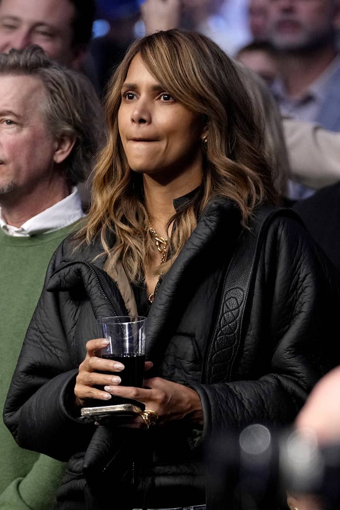 Berry holds a cup of wine in the audience