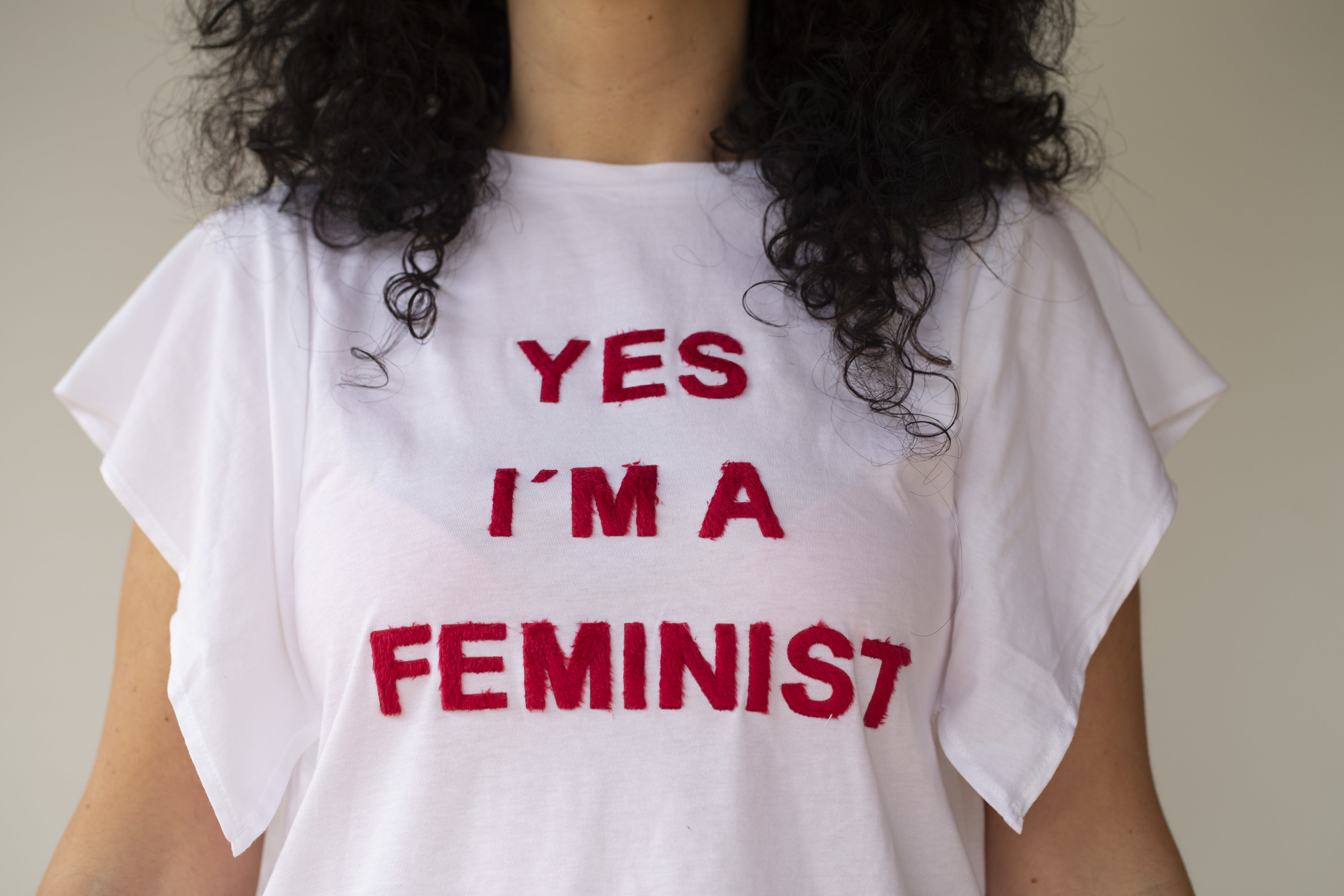 close up of a woman wearing a tee shirt that reads &quot;yes I&#x27;m a feminist&quot;