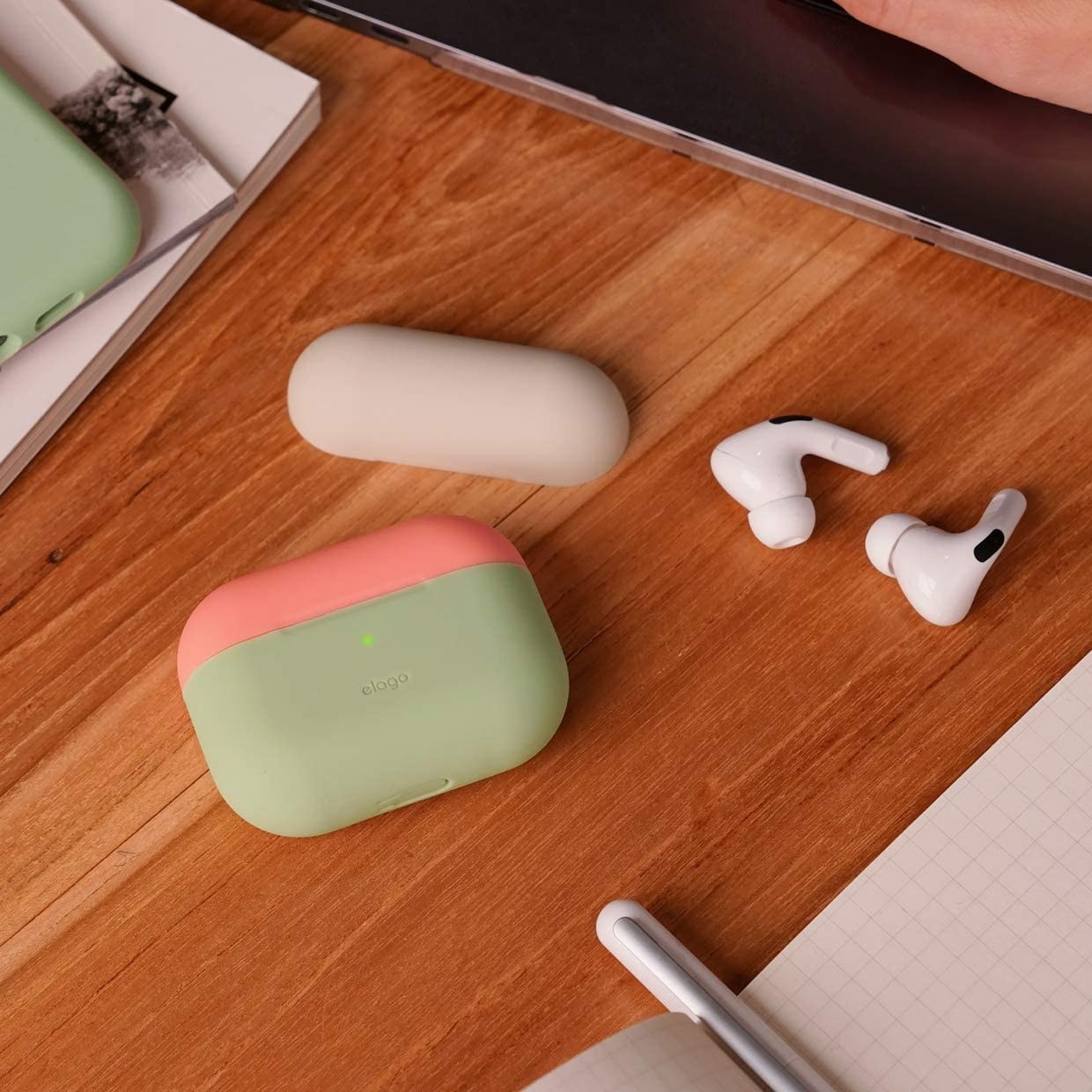 A pair of AirPods Pro beside the case on a wooden table