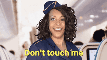 Comedian Holly Logan dressed as a flight attendant says, &quot;Don&#x27;t touch me&quot; when someone reaches over with their hand
