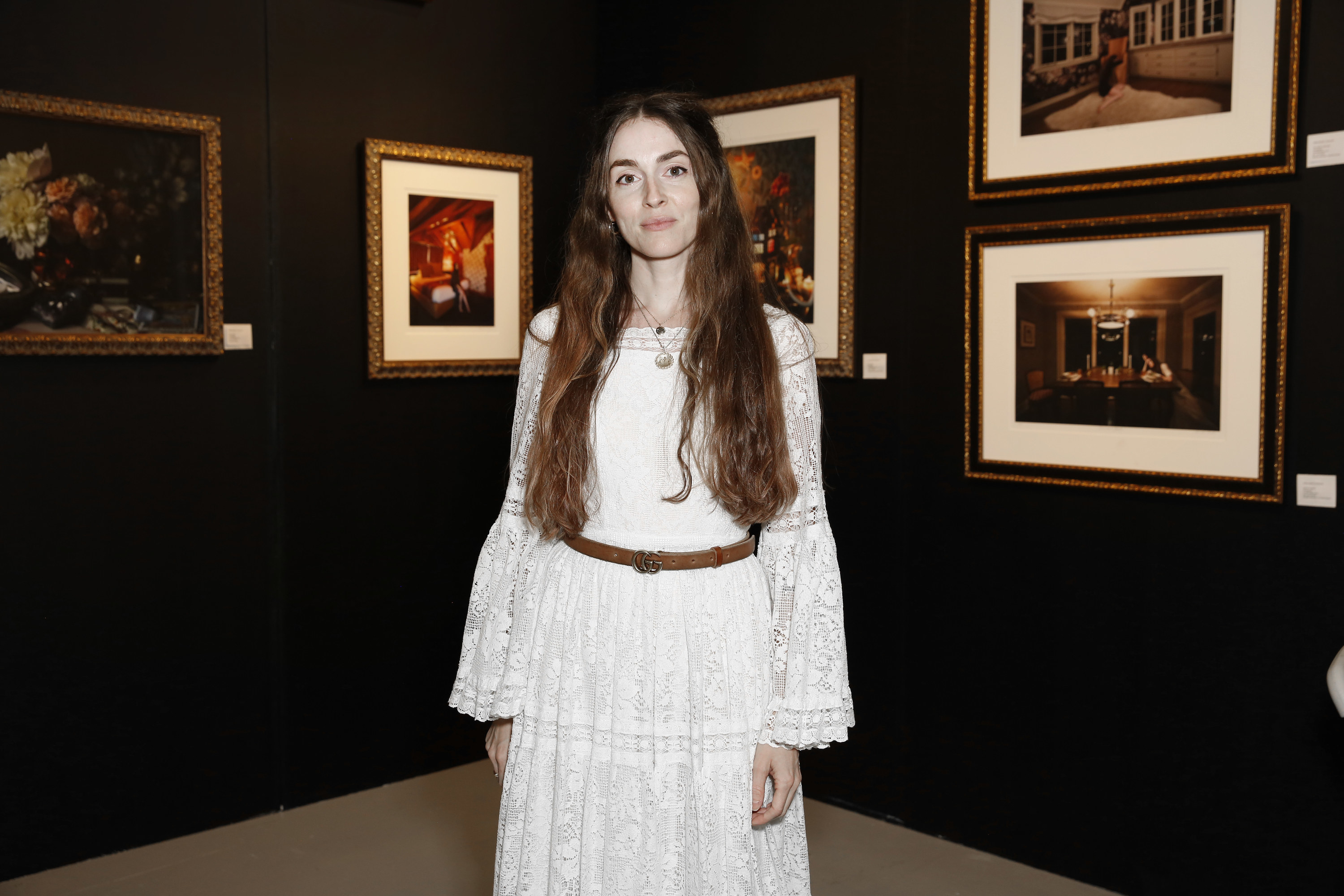 Anna Marie standing in a gallery with artwork on the walls behind her