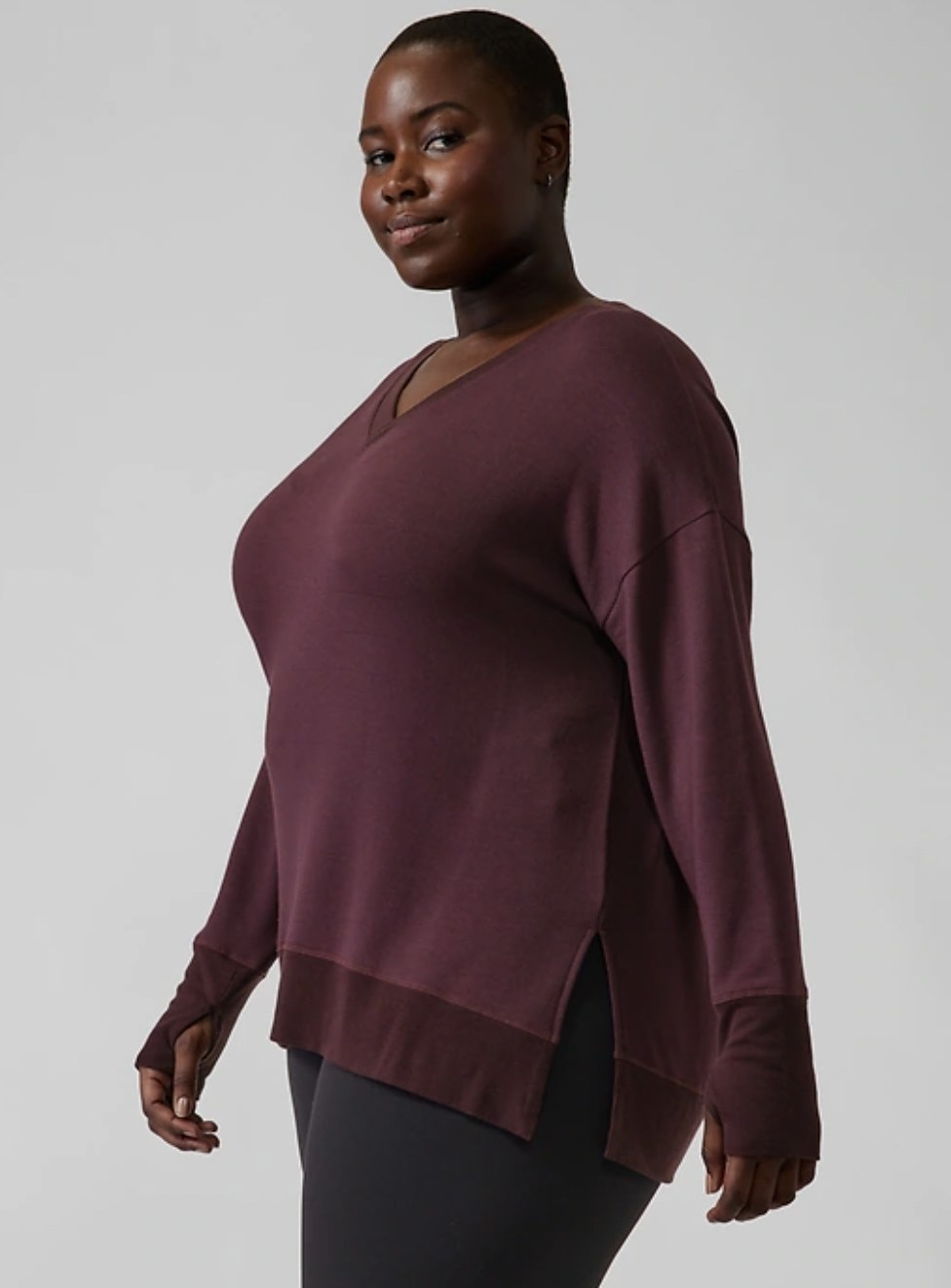 Model wearing the deep red v-neck sweater with thumbholes