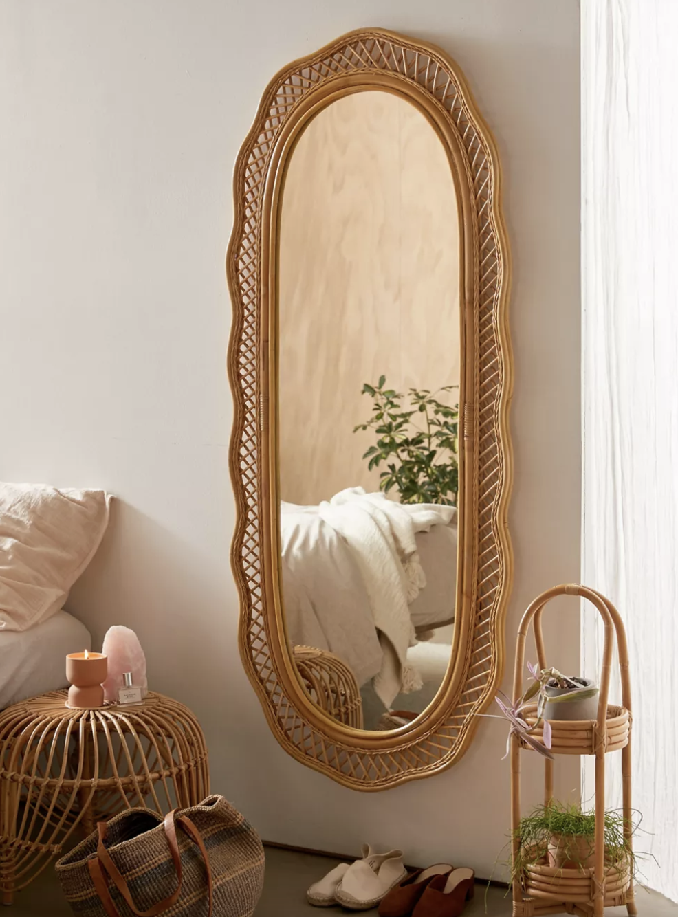 the malorie wicker mirror mounted on a wall