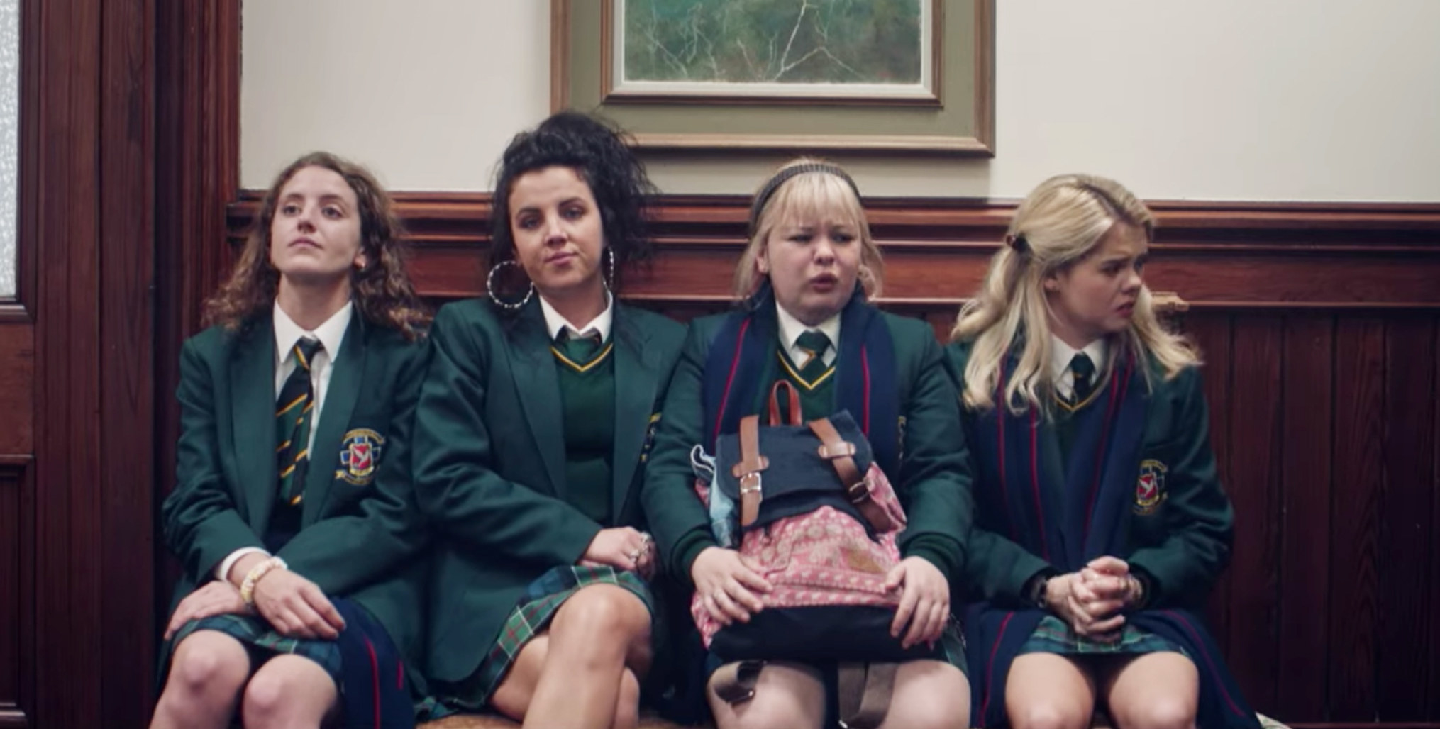 Louisa Harland, Jamie-Lee O&#x27;Donnell, Nicola Coughlan, and Saoirse-Monica Jackson sit on a bench together in various stages of distress as Orla, Michelle, Clare, and Erin on &quot;Derry Girls&quot;