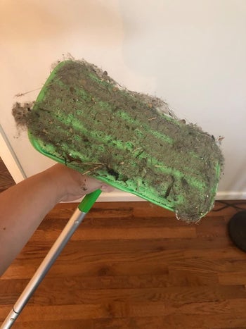 Reviewer showing used sweeping pad with dirt and hair