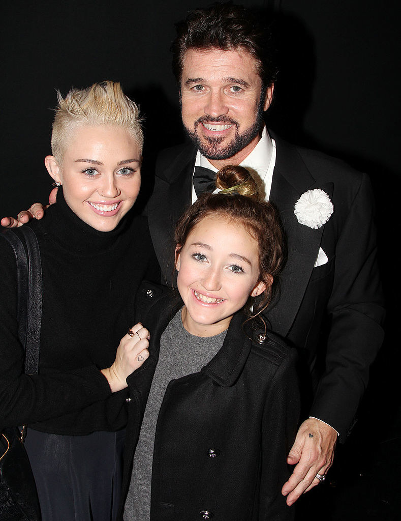 Miley, Noah, and Billy Ray on a red carpet