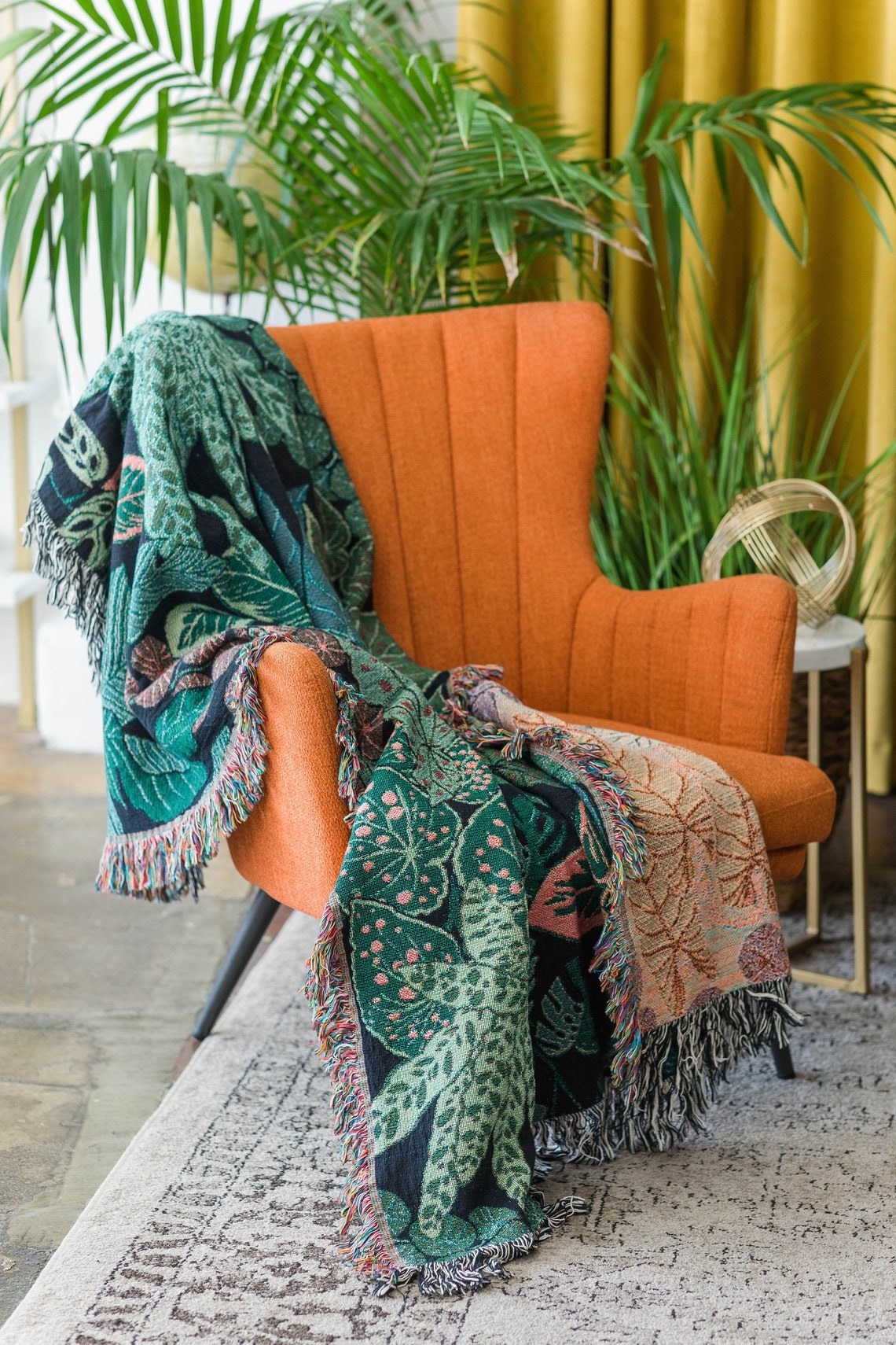 botanical woven throw blanket draped over orange arm chair