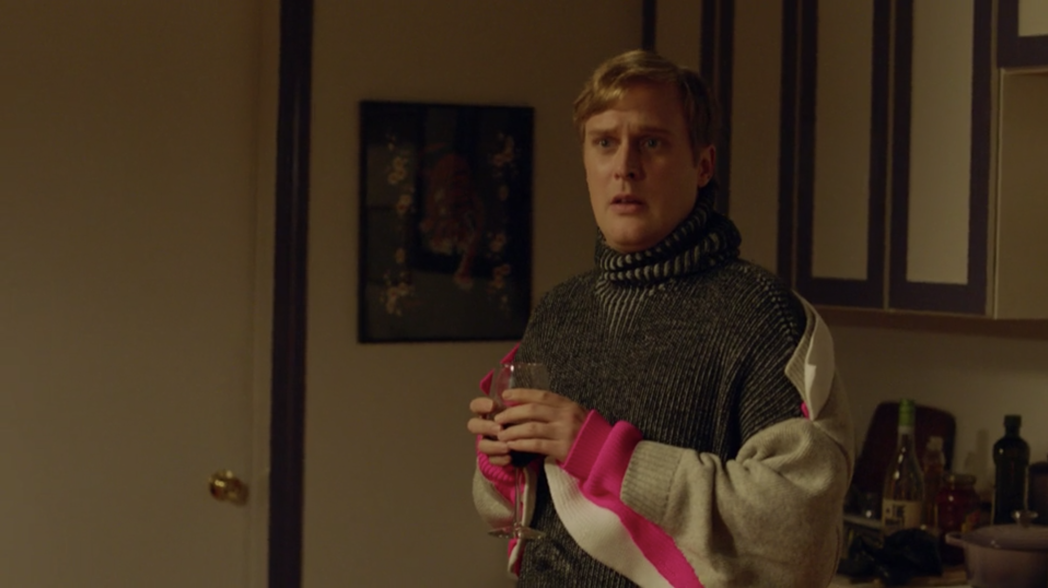 John Early holding a glass of wine.