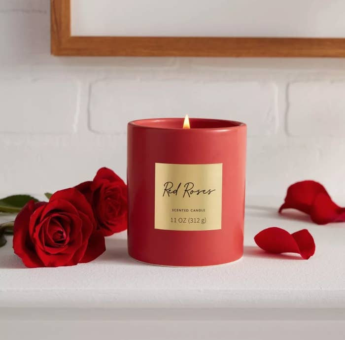 the red roses scented candle next to roses