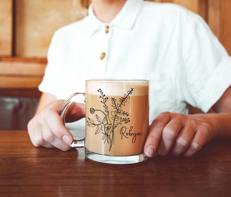 a glass mug with wild flowers on it and the name &quot;robyn&quot; in script