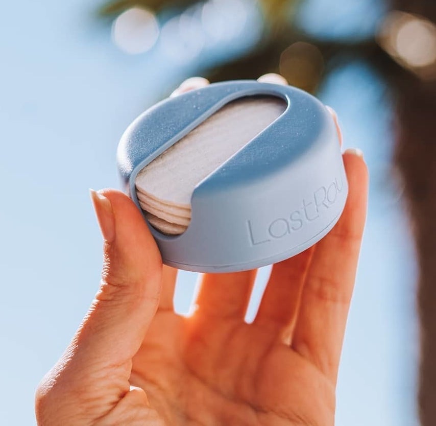 A person holding a container of reusable cotton rounds
