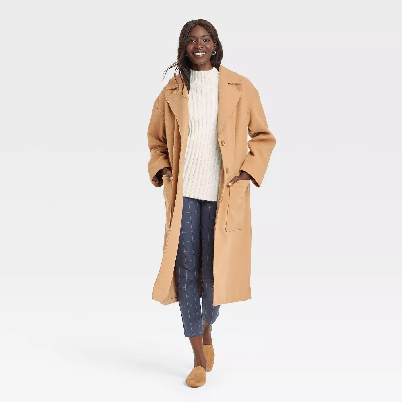 Model wearing camel colored coat with pockets