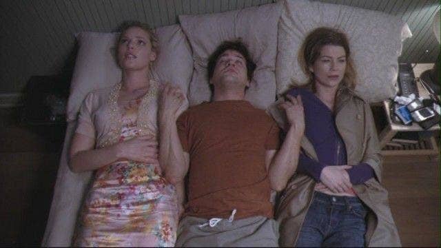 Izzie, George, and Meredith lie on top of bed together