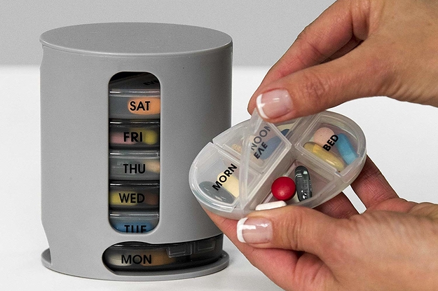 The organizer, with hands holding one day, showing the compartments which say morn, noon, eve, and bed